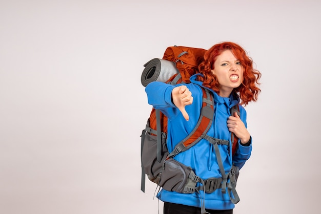Turista de frente para uma viagem na montanha com mochila descontente