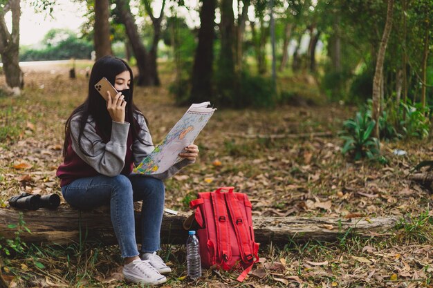 Turista de mulher asiática usando máscara facial. Conceito de viagens do vírus da gripe coronavírus