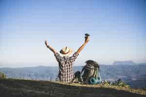 Foto grátis turista do topo da montanha. raios solares. homem usar mochila grande contra a luz do sol