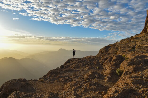 Turista no topo de uma montanha rochosa em Gran Canaria, Espanha