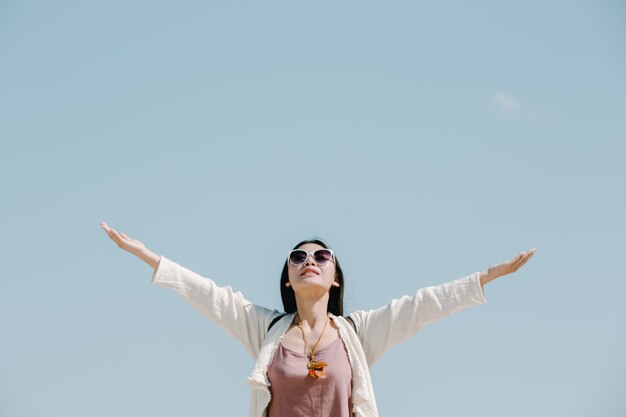 Turistas femininas espalham seus braços e seguram suas asas