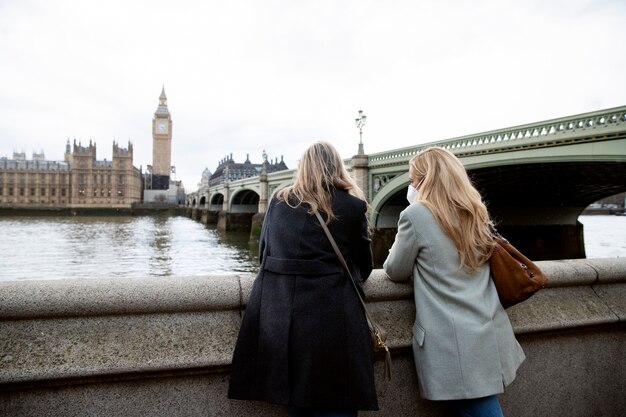 Foto grátis turistas visitando a cidade e usando máscara de viagem