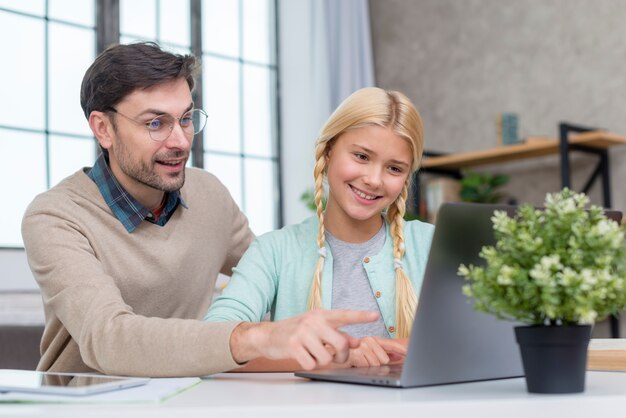 Tutor em casa e aluno olhando para a tela