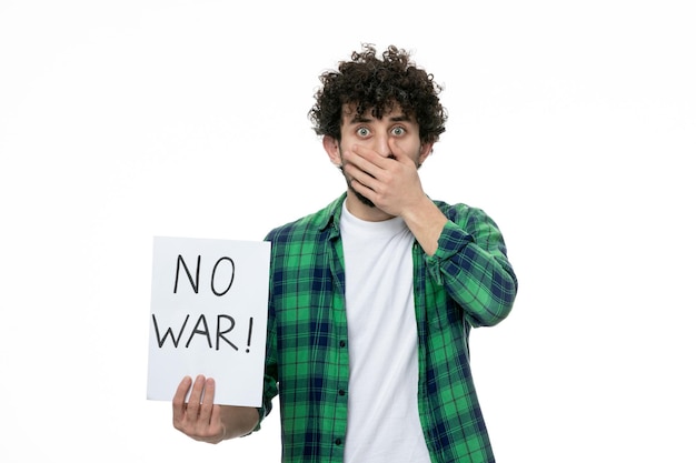 Foto grátis ucrânia conflito russo bonito jovem morena de camisa verde segurando nenhum sinal de guerra