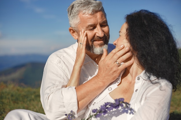 Último homem e mulher nas montanhas. casal adulto apaixonado ao pôr do sol. homem de camisa branca.