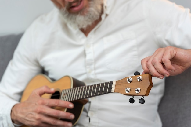 Foto grátis Último homem em casa tocando cavaquinho no sofá