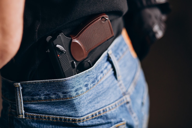 Foto grátis um ator bonito posando no estúdio com uma arma.