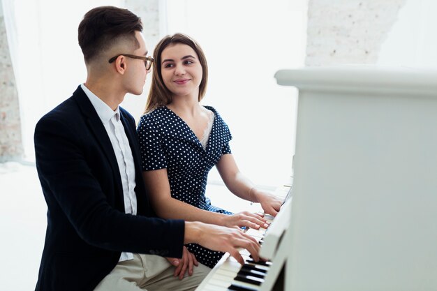 Um, atraente, par jovem, piano jogando, olhando um ao outro