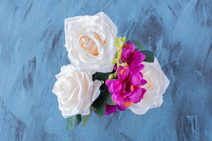 Foto grátis um balde metálico cheio de lindas flores coloridas em azul.