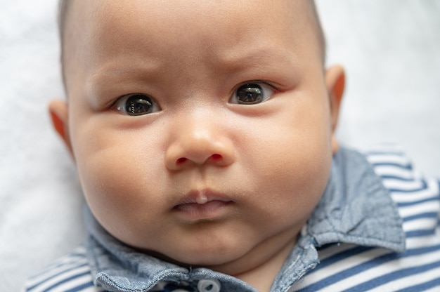 Um bebê recém-nascido que abre os olhos e olha para a frente