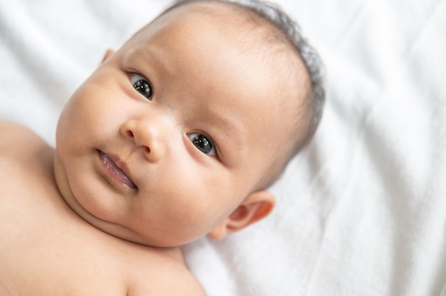 Um bebê recém-nascido que abre os olhos e olha para a frente