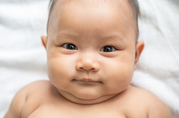 Um bebê recém-nascido que abre os olhos e olha para a frente