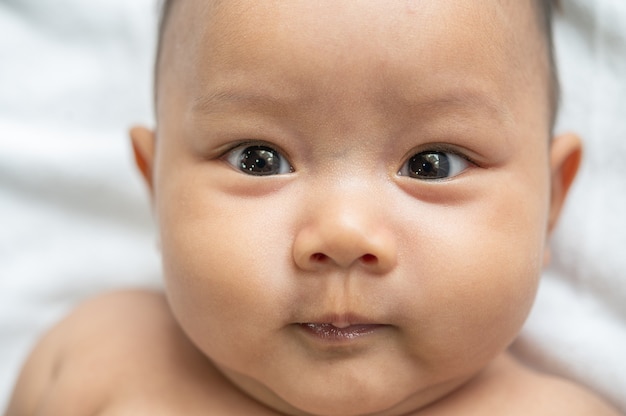 Um bebê recém-nascido que abre os olhos e olha para a frente