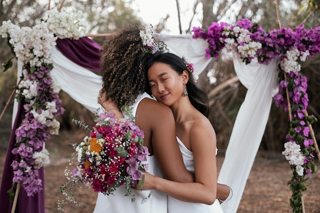 Foto grátis um belo casal de lésbicas a celebrar o dia do casamento ao ar livre.