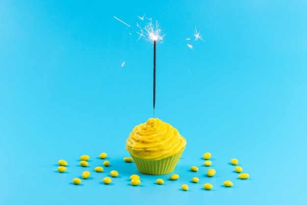 Foto grátis um bolo amarelo de frente com doces amarelos na mesa azul, cor de biscoito doce de açúcar