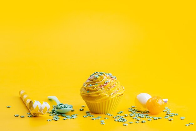 Um bolo amarelo de vista frontal delicioso e saboroso junto com doces em forma de estrela verde em uma mesa amarela