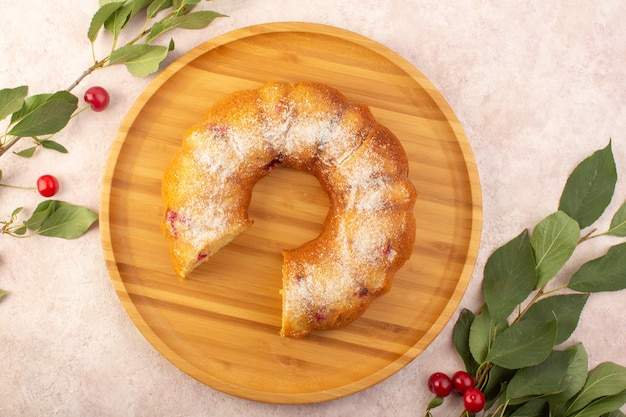 Um bolo de cereja com vista de cima na mesa de madeira com cerejas na mesa rosa bolo biscoito açúcar doce