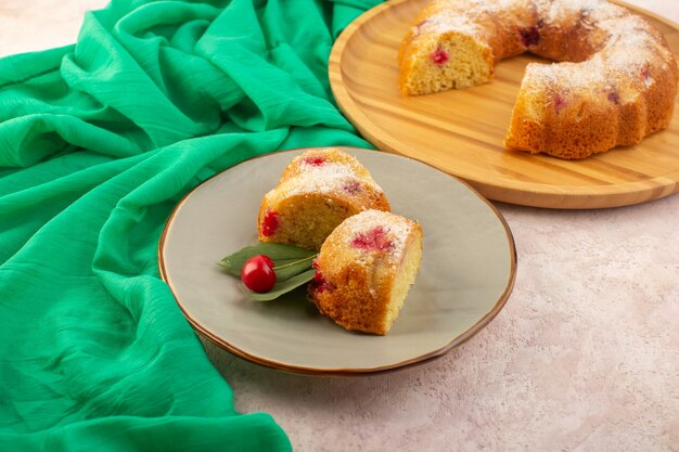 Um bolo de cereja com vista frontal fatias deliciosas e gostosas na mesa rosa