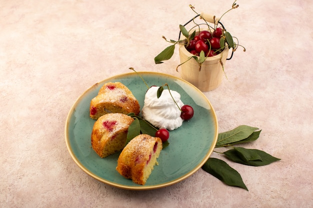 Um bolo de frutas assado delicioso fatiado com cerejas vermelhas dentro e açúcar em pó dentro de uma placa verde redonda rosa