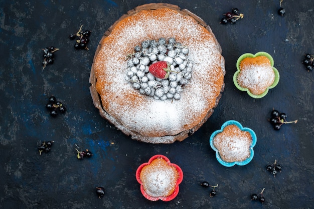 Um bolo de frutas delicioso e redondo formado com azul fresco, bagas no escuro, biscoito doce com açúcar