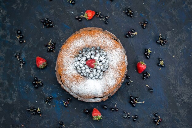 Um bolo de frutas delicioso e redondo formado com azul fresco, bagas no escuro, biscoito doce com açúcar