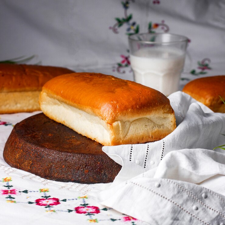 Foto grátis um bolo de massa colocado na toalha de mesa com bordado tradicional