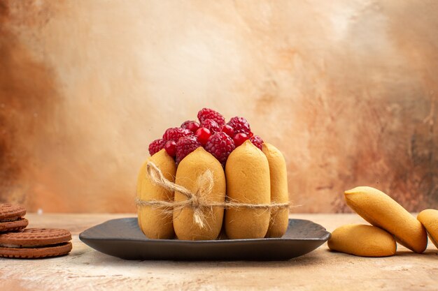 Um bolo de presente e biscoitos em pratos marrons frutas na mesa de cores diferentes