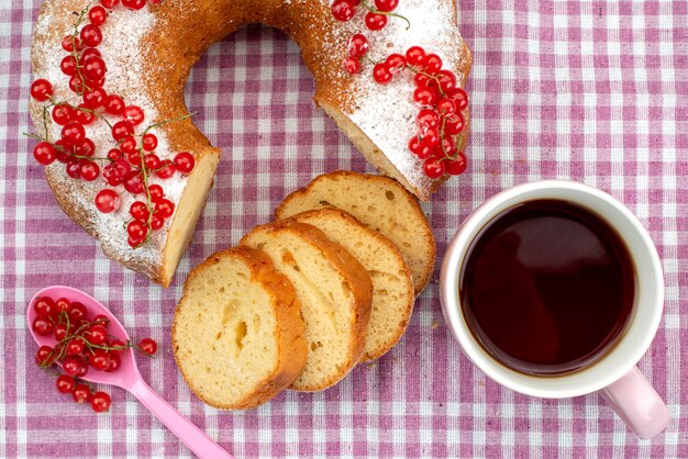 Um bolo delicioso com cranberries vermelhas frescas, canela e chá no bolo de tecido roxo biscoito chá e açúcar