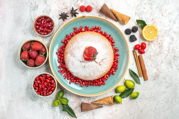 um bolo um bolo com romã paus de canela taças de frutas vermelhas limão anis estrelado