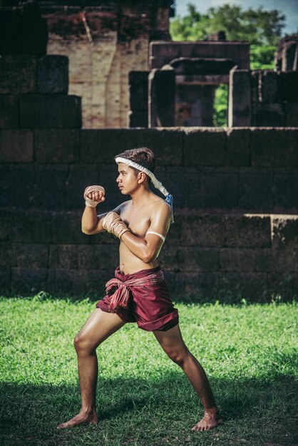 Um boxeador amarrou uma corda na mão e realizou uma luta, as artes marciais do Muay Thai.