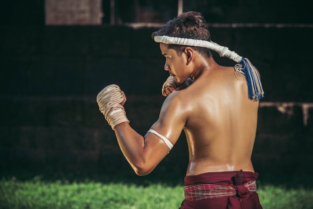 Um boxeador amarrou uma corda na mão e realizou uma luta, as artes marciais do muay thai.