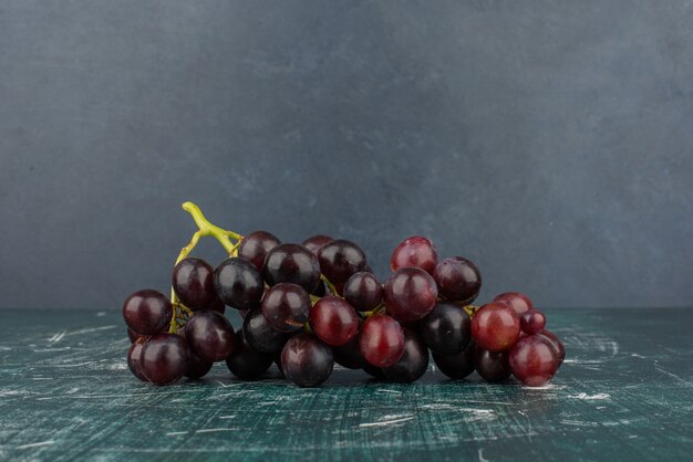 Um cacho de uvas pretas na mesa de mármore.