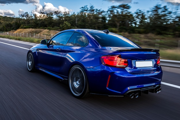 Um carro azul dirigindo na estrada.