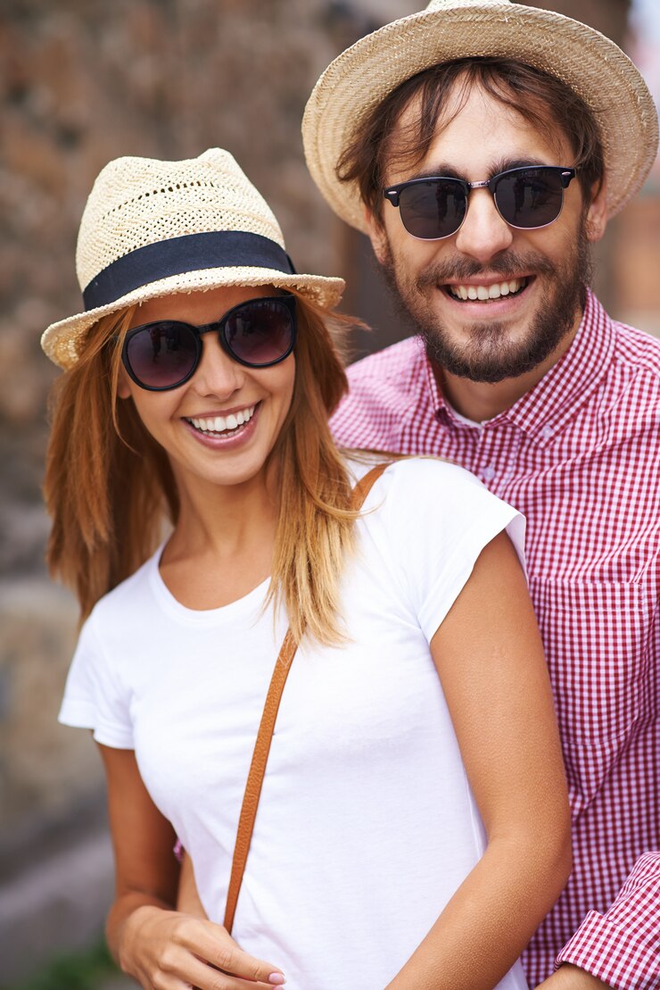 Foto grátis um casal adorável com chapéus e óculos de sol.