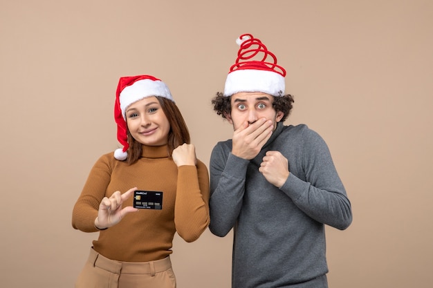 Um casal está parado ao lado da árvore de natal