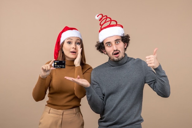 Um casal está parado ao lado da árvore de Natal