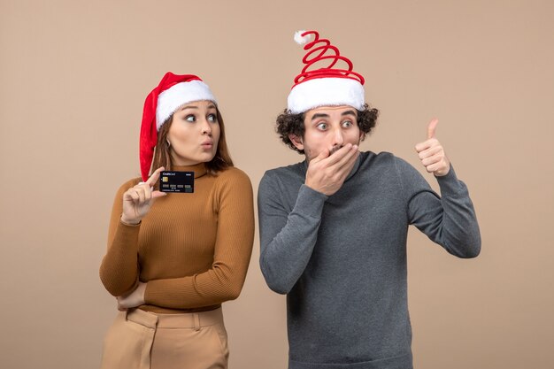 Um casal está parado ao lado da árvore de Natal