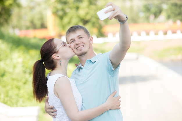 Um casal fazendo selfie no parque