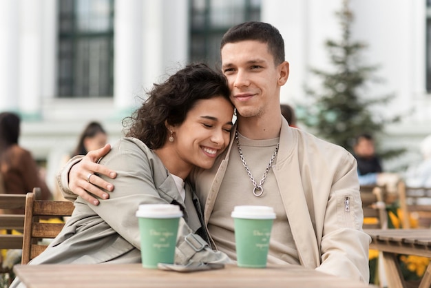 Um casal feliz ao ar livre perto de um café