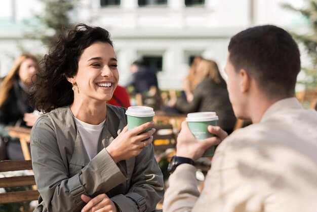 Um casal feliz ao ar livre perto de um café
