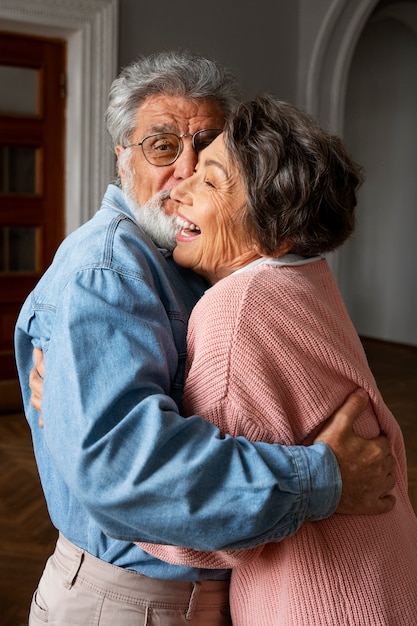 Um casal sorridente abraçando uma vista lateral