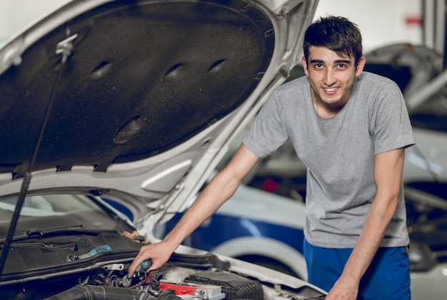 Foto grátis um colega de trabalho reparando o motor de um carro