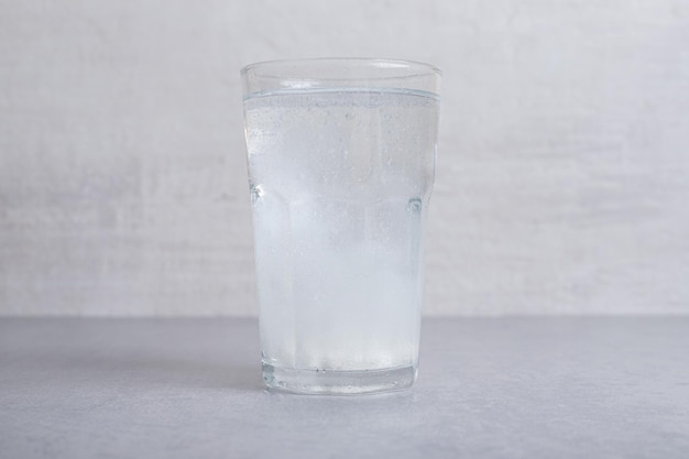Um copo de água fria pura em fundo cinza.