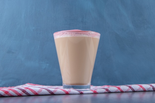 Foto grátis um copo de cappuccino em um pano de prato, na mesa de mármore.