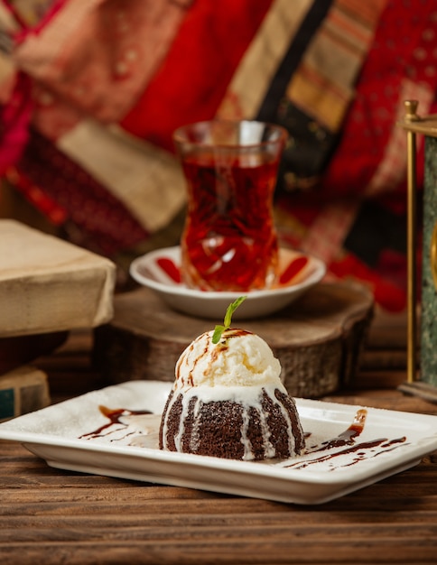 Um copo de chá com torta de chocolate com creme.