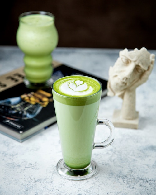 Um copo de chá verde matcha com latte art no topo 1