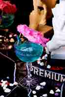 Foto grátis um copo de cristal com haste longa e lagoa azul decorada com algodão doce rosa