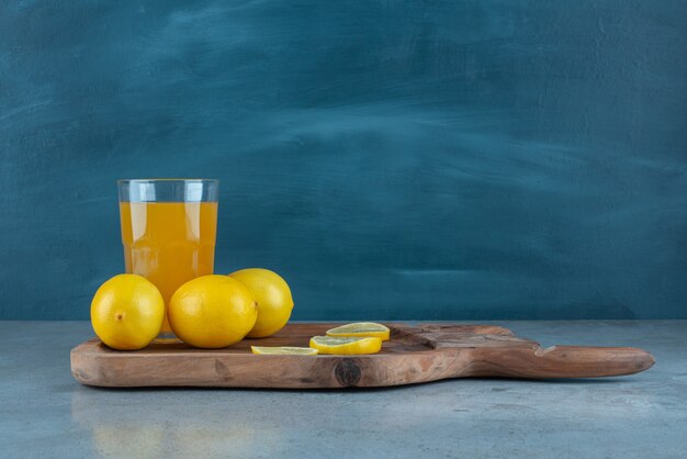 Um copo de suco de laranja com limões frescos.