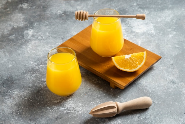 Um copo de suco de laranja e um alargador de madeira.