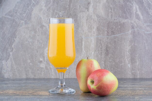 Um copo de suco de laranja no fundo de mármore. Foto de alta qualidade